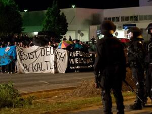 Police face far-right activists protesting the opening of a new center for refugees. (AFP/File)