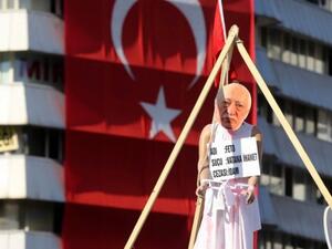 A picture of US-based preacher Fethullah Gulen placed on a hanging dummy in front of a Turkish national flag at Kizilay Square in Ankara on August 2, 2016, during a protest against July's failed military coup. (AFP/Adem Altan)