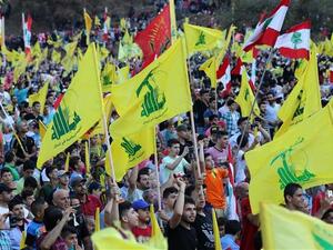 Lebanese people wave flags of Hezbollah in a ceremony on August 14, 2015. (AFP/File)