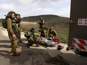 Israeli soldiers prepare on Tuesday to evacuate a comrade injured in a blast on the occupied Golan Heights near the village of Majdal Shams. (AFP/File)