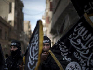 Members of Liwa Hamzah, a newly formed Islamist brigade from the Syrian eastern city of Deir Ezzor, hold flags of Jabhat Al-Nusra on Feb. 25, 2013. (AFP/File)