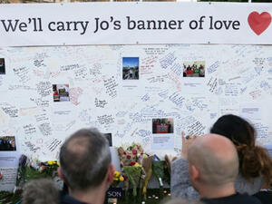 People stand in front of a large board in Parliament Square, central London, bearing messages in remembrance of murdered Labour MP Jo Cox. (AFP/File)