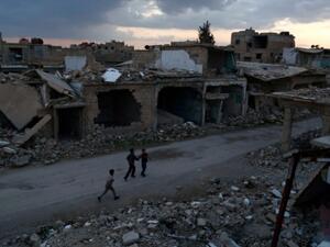 Syrian children walk past heavily damaged buildings in the rebel-held town of Douma, on the eastern edges of Damascus on February 27, 2016. (AFP/Sameer Al-Doumy)