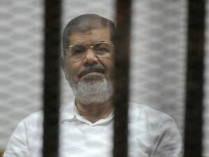 Egypt's deposed president Morsi sits behind the defendants cage during a court trial in Cairo on November 5, 2014. (AFP/File) 