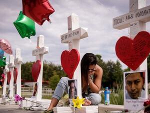 A woman writes a note on a cross at a memorial for each of the 49 victims of the Pulse Nightclub, next to the Orlando Regional Medical Center, June 17, 2016 in Orlando, Florida. (AFP/Drew Angerer)