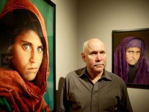 Ulrich Perrey US photographer Steve McCurry poses next to his photos of the "Afghan Girl" named Sharbat Gula. (AFP/File)