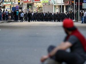 A protester sits in front of riot policemen during a demonstration on April 15, 2016 in central Cairo against a controversial deal to hand two islands in the Red Sea to Saudi Arabia. (AFP/Mohamed El-Shahed)