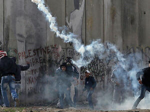 Palestinians throw rocks as Israeli occupation forces shoot teargas in Qalandia. (AFP/File)