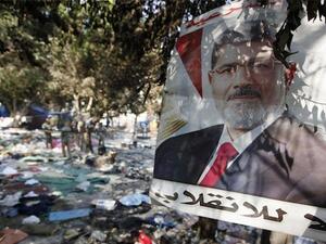 A picture of Egypt's ousted president Mohamed Morsi is seen hanging amidst debris at Rabaa al-Adawiya square in Cairo. (AFP/Mahmoud Khaled)