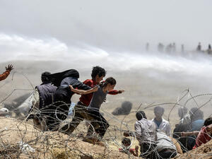 Turkish soldiers use water cannon to move Syrian refugees from border fences at Akcakale in Sanliurfa province, on June 13, 2015. (AFP/Bulent Kilic) Turkish soldiers use water cannon to move Syrian refugees from border fences at Akcakale in Sanliurfa province, on June 13, 2015. (AFP/Bulent Kilic)