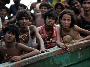 Rohingya migrants sit on a boat drifting in Thai waters off the southern island of Koh Lipe in the Andaman sea on May 14, 2015. The boat was found drifting in Thai waters on May 14, according to an AFP reporter at the scene, with passengers saying several people had died over the last few days. (AFP/Christophe Archambault) 