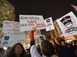 Egyptian protesters hold up placards and shout slogans during a demonstration in Cairo against sexual harassment on February 12, 2013. (AFP/File)
