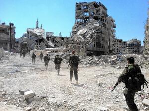 Syrian regime forces patrolling a city devastated by conflict. (AFP/File)