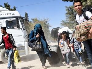 Syrian refugees walk on their way back to the Syrian city of Jarabulus on September 7, 2016 at Karkamis crossing gate, in the southern region of Kilis, Turkey. (AFP/Bulent Kilic)