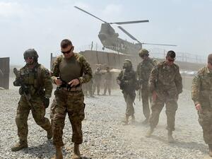U.S. Army soldiers walk as a NATO helicopter flies overhead at coalition force Forward Operating Base (FOB) Connelly in the Khogyani district in the eastern province of Nangarhar on August 13, 2015. (AFP/Wakil Kohsar)