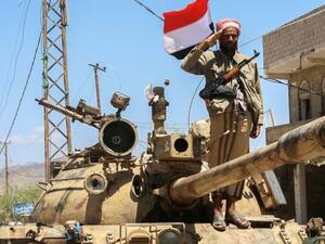 A Yemeni fighter loyal to the country's exiled president salutes on top of a tank at a checkpoint in Taez on Apr 11, 2016. (AFP/Ahmad Al-Basha)