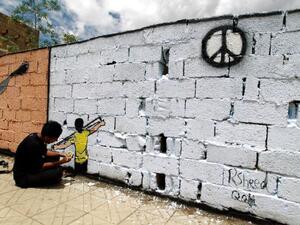 A Yemeni artist sprays graffiti on a wall in the capital Sanaa in support of peace. (AFP/File)