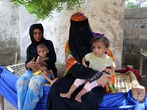 Yemeni women sit with their malnourished children on September 26, 2016 in an impoverished coastal town. (AFP/File)