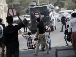 Bahraini youth holding signs calling for the boycott of the parliamentary elections, during a rally in the village of Diraz, west of Manama on November 21, 2014. (AFP/Mohammed al-Shaikh)