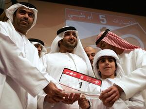 Emirati Saed Abdul Ghaffar al-Khouri poses with the most expensive car number-plate after he won it in an Abu Dhabi auction in 2008 (AFP/File Photo)	