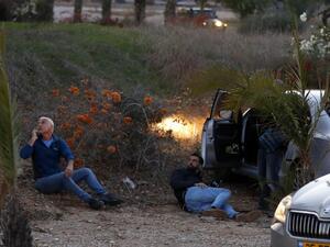 Israelis take cover as rockets are fired from the Gaza Strip, in the southern Israeli town of Sderot on November 12, 2018. (Jack GUEZ / AFP)