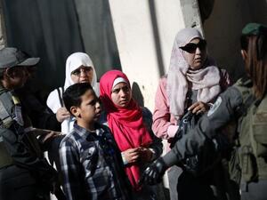 A Palestinian family at an Israeli checkpoint between the West Bank town of Bethlehem and Jerusalem. (AFP Photo/Thomas Coex)
