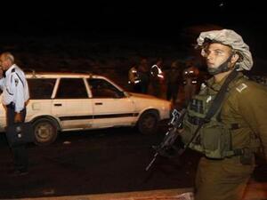 جندي اسرائيلي بجوار السيارة التي قتل فيها اربعة اسرائيليين
