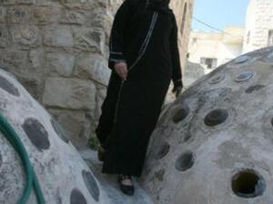 الفلسطينية زهيرة قفيشة تتنقل على اسطح بيوت شارع الشهداء في الخليل بعد ان باتت المنفذ الوحيد الى منزلها