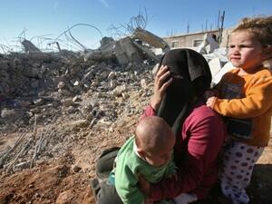 عائلة فلسطينية تجلس في العراء بعد ان هدمت قوات الاحتلال منزلها في قرية يطا في الخليل/أ.ف.ب