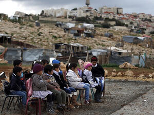A Palestinian teacher leads a class of Palestinian bedouin children from the Abu Nawar community near the Jewish settlement of Maale Adumim (background), in the West Bank town of al-Azariya, east of Jerusalem. (AFP/file)