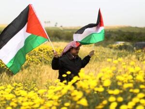 فلسطيني يحمل العلم الوطني في بيت حنينا خلال احياء يوم الارض/أ.ف.ب