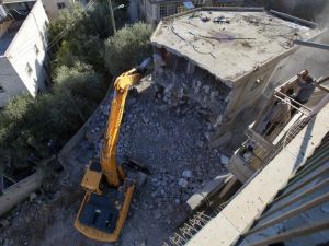 فلسطيني ينظر على جرافات الاحتلال وهي تدمر منزله في قرية صور بار في القدس الشرقية/أ.ف.ب