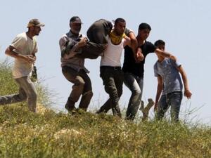 فلسطينيون يسعفون جريحا اصيب في المواجهات مع المستوطنيين في الضفة/أ.ف.ب