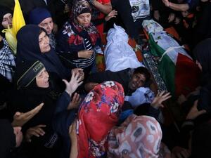Palestinians mourn over the bodies of Maram Abu Ismail, 23, and her brother Ibrahim Taha, 16, who were shot dead by Israeli police last month at the Qalandiya checkpoint, during their funeral in the West Bank village of Qatanna, on May 23, 2016. (AFP/Abbas Momani)