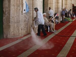 A Palestinian man clears the damage at the entrance of Al-Aqsa Mosque in Jerusalem's Old City after clashes erupted at the compound between Palestinians and Israeli police on June 26, 2016 during the holy month of Ramadan. (AFP/Ahmad Gharabli)