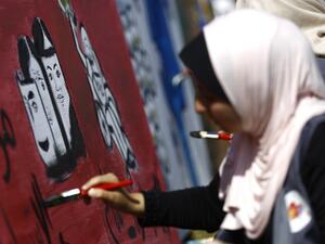 A Palestinian art student paints as she takes part in a festival marking the World Mental Health Day on October 11, 2016 in Gaza City. (AFP/Mohammed Abed)