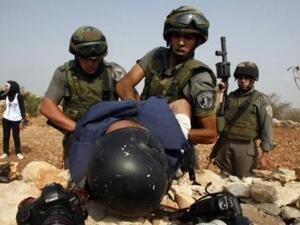 Israeli soldiers detain a Palestinian journalist during a demonstration. (AFP/File)