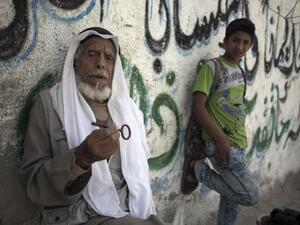 Ibrahim Abu Mustaf, 83, who says he is a former inhabitant of the town of Beersheva, carries the key to his former home in the Khan Yunis refugee camp in the southern Gaza Strip on May 15, 2016, on the 68th anniversary of the Nakba. (AFP/Said Khatib)