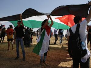 Arab-Israeli protesters hold a large Palestinian flag as they march for the right of return for Palestinian refugees who fled their homes or were expelled during the 1948 war that followed the creation of the state of Israel, near the southern Israeli Bedouin of Rahat on May 12, 2016. (AFP/Ahmad Gharabli)