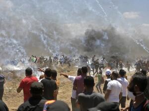 Palestinian protesters run for cover from tear gas during clashes with Israeli forces near the border between the Gaza strip and Israel east of Gaza City on May 14, 2018, as Palestinians protest over the inauguration of the US embassy following its controversial move to Jerusalem. (MAHMUD HAMS/ AFP)