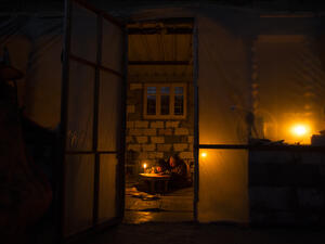 A Palestinian woman helps her son study, by candlelight, at their makeshift home in the Khan Yunis refugee camp in the southern Gaza Strip on April 19, 2017. (AFP/Mahmud Hams)
