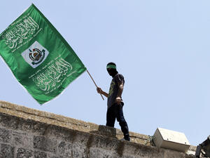 In a file photo, a demonstrator carries a Hamas flag on the roof of occupied Jerusalem's Al-Aqsa mosque, June 3 2015. (AFP/Ahmad Gharabli)