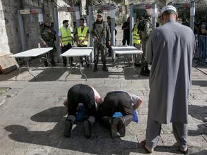Palestinians worship outside al-Aqsa compound in protest against security measures (Ahmad Gharabli/AFP)