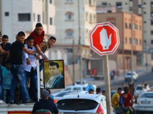 Palestinian youths hold a framed portrait of Mohammed Dahlan, an exiled senior Fatah official and rival to Mahmoud Abbas who was sentenced in absentia to three years in prison on corruption charges, during a wedding in Gaza City, on June 29, 2017. (Mohammed Abed/AFP)