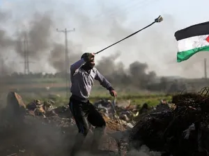 Palestinian protesters hurls a rock at Israeli security forces during clashes near the Shejaiya area of Gaza City along the border with Israel. (AFP PHOTO/MAHMUD HAMS)
