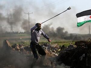 Palestinian protesters hurls a rock at Israeli security forces during clashes near the Shejaiya area of Gaza City along the border with Israel. (AFP PHOTO/MAHMUD HAMS)
