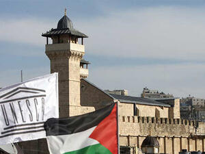 The Palestinian Rehabilitation Committee raised the UNESCO flag next to the national Palestinian flag in front of Hebron's Ibrahimi Mosque or the Tomb of the Patriarchs. (Hazem Bader/ AFP)