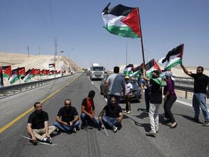 Palestinian protesters block the road during a protest along a highway leading to Khan al-Ahmar in support of its residents. (AFP/File)