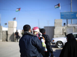Man holds his child as they wait to cross at Erez between Gaza and Israel earlier this year. (AFP/File) 