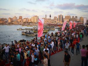 Palestinians walk on the red carpet during a film festival showcasing films focusing on human rights, in Gaza City on May 12, 2017. (AFP/Mohammed Abed)